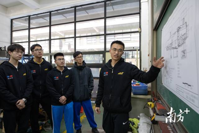 杨浩森正在向其他成员讲解车辆底盘的构造与所应用的技术。 